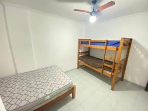 a bedroom with a bunk bed and a ceiling fan at Pé na areia praia da Guilhermina III in Praia Grande