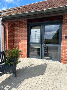 a glass door of a brick building with a bench at Ferienwohnungen mit Feldblick in Schwerin