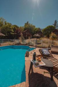 a swimming pool with a table and a picnic table next to it at Cabañas Dalga Inn in Merlo