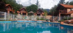 a large swimming pool in front of a house at Cabañas Dalga Inn in Merlo