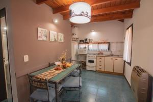 a kitchen with a table and chairs in a room at Cabañas Dalga Inn in Merlo