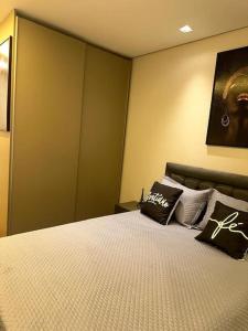 a bedroom with a bed with two pillows on it at Studio bem localizado in Jaú