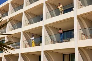 a group of people standing on the balconies of a building at W Algarve in Albufeira