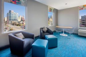 a waiting room with chairs and a table and a window at aloft Hotel Milwaukee Downtown in Milwaukee +42 photos