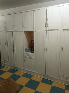 einem Schrank mit weißen Schränken und einem karierten Boden in der Unterkunft TIBA HOUSe in Luxor