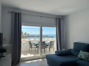 un soggiorno con divano e vista sull'oceano di Casa Adamar Vibbecanarias, Puerto Rico a Puerto Rico de Gran Canaria