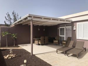 a pavilion with chairs and a table on a patio at Annelie Comfortable Holiday Residence in La Pared