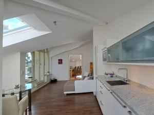 Una cocina con gabinetes blancos y una sala de estar. en Havelpalais Comfortable holiday residence, en Potsdam