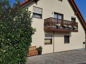 a building with a balcony on the side of it at Tromm - Blick Comfortable holiday residence in Rimbach