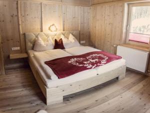 a bedroom with a large bed in a room with wooden walls at Jogglelerhof Comfortable holiday residence in Finkenberg