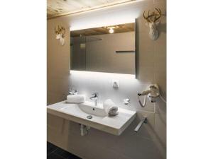 a bathroom with a sink and a mirror at Jogglelerhof Comfortable holiday residence in Finkenberg +12 photos