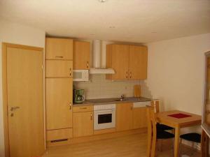 a small kitchen with wooden cabinets and a table at Lea Comfortable holiday residence in Niederthai