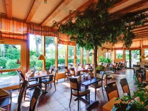 restauracja ze stołami, krzesłami i oknami w obiekcie Holiday Apartment at the Golf Course F 19 O w mieście Fehmarn