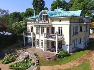 Casa blanca grande con techo verde en Havelpalais Comfortable holiday residence, en Potsdam
