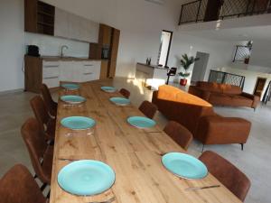 a long wooden table with blue plates on it at Bagulina Comfortable holiday residence in Drniš