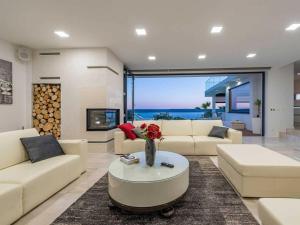 a living room with couches and a vase of flowers on a table at Luxury Villa Michele with heated pool in Jasenice