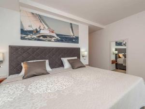 a bedroom with a large white bed with a headboard at Luxury Villa Michele with heated pool in Jasenice +38 photos