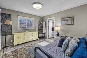ベンドにあるAspen Bungalow - Meredith Lodgingのベッドルーム1室(ベッド1台、黄色いドレッサー付)