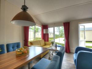 a living room with a table and blue chairs at Seemöwe F180 Comfortable holiday residence in Fehmarn +16 photos