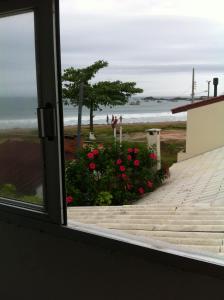 una ventana con vistas a la playa desde una casa en Apartamento Proximo Ao Mar, en Florianópolis