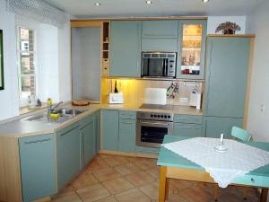 a kitchen with blue cabinets and a table and a tableablish at Brentel family Comfortable holiday residence in Vehlin