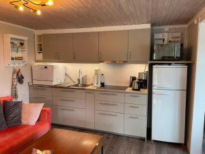 a kitchen with white cabinets and a red couch at 4 star holiday home in Vingåker in Julita +15 photos