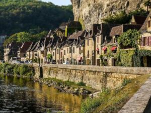 una fila de casas a orillas de un río en Scenic villa with swimming pool, en Combe-Molière