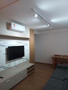 ein Wohnzimmer mit Flachbildfernseher und Couch in der Unterkunft Apartamento Frente Mar in Barra Velha