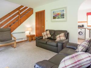 una sala de estar con un sofá y una silla en Aonach Cottage - Uk41932, en Glencoe