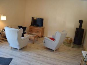 a living room with two chairs and a tv at Köhler - Hütte Comfortable holiday residence in Brilon