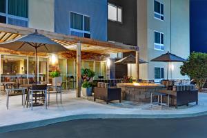 an outdoor patio with tables and chairs and umbrellas at TownePlace Suites by Marriott Jacksonville East in Jacksonville