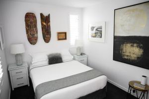 奥克兰Omahanui - City fringe guesthouse的卧室配有一张床,墙上设有两个冲浪板
