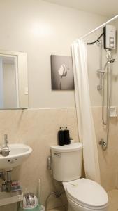 a bathroom with a toilet and a sink at Cozy 1-bed unit near SRP Talisay Cebu in Talisay