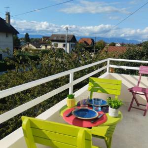 a table with a plate of food on a balcony at Appartement verdoyant au bord du lac Leman entre Evian et Thonon dans une Villa in Publier