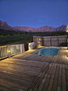 a wooden deck with a swimming pool on a patio at MAGNIFICENT 6 sleeper mountain getaway in Romansrivier