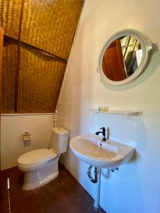 a bathroom with a toilet and a sink and a mirror at Phu Aunna in Ko Phayam