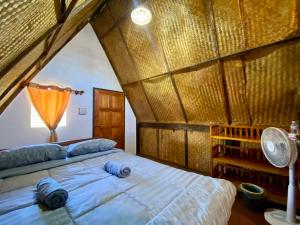 a bedroom with a large bed with a wooden ceiling at Phu Aunna in Ko Phayam