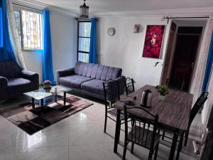 una sala de estar con un sofá y una mesa en Makeena Berry Cosy Mboa - MOLYKO, en Douala