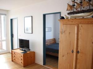 a bedroom with a bunk bed and a desk with a television at Föhrweh Comfortable holiday residence in Wyk auf Föhr +4 photos
