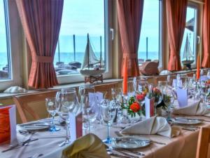 a dining room with a table with wine glasses at Seemöwe F183 Comfortable holiday residence in Fehmarn +16 photos