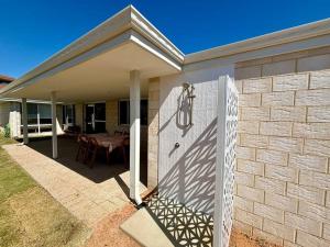 a white door on a house with a table at Abrolhos Beach House in Geraldton