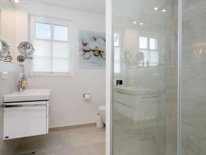 a white bathroom with a shower and a toilet at Holiday Home Traumzeit I in Zingst +13 photos