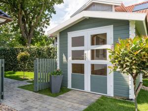 a small blue and white shed with a window at Holiday Home Traumzeit I in Zingst