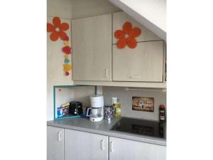 a kitchen with white cabinets with flowers on the wall at Lobbe mit direkter Strandlage in Middelhagen