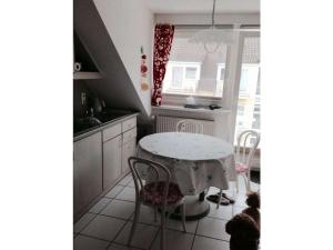 a kitchen with a table and a cat sitting around it at Lobbe mit direkter Strandlage in Middelhagen +18 photos