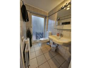a bathroom with a sink and a toilet and a window at Raphael - "Elvis Presley" in Timmendorfer Strand +9 photos