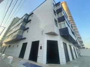 Cantinho à beira mar في برايا جراندي: مبنى أبيض طويل بأبواب ونوافذ سوداء +12 صورة