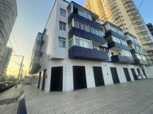 Cantinho à beira mar في برايا جراندي: مبنى طويل به أبواب سوداء على جانبه