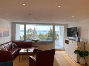 una sala de estar con sofá y un barco en la ventana en Apartment Annemarie 1, en Meersburg