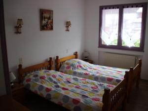 two twin beds in a bedroom with a window at Maison spacieuse 18 pers, 8 ch, cheminée, jardin clos, 4* - FR-1-737-84 in Autrans +4 photos